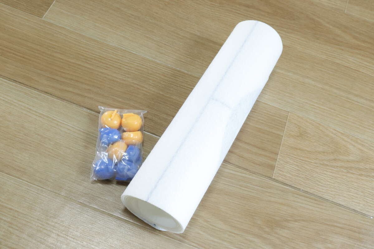 巻かれた白いカーリングマットとストーンの袋 巻かれた白いカーリングマットとストーンの袋