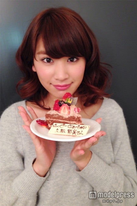 誕生日ケーキを手に笑顔