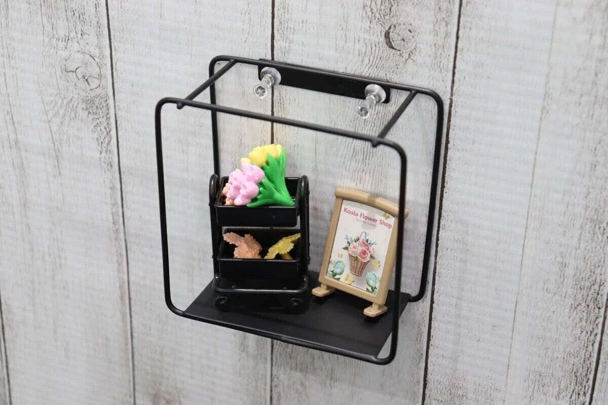 黒いアイアン壁掛け収納が木目調の白い壁に取り付けられミニチュア雑貨が飾られている 黒いアイアン壁掛け収納が木目調の白い壁に取り付けられミニチュア雑貨が飾られている
