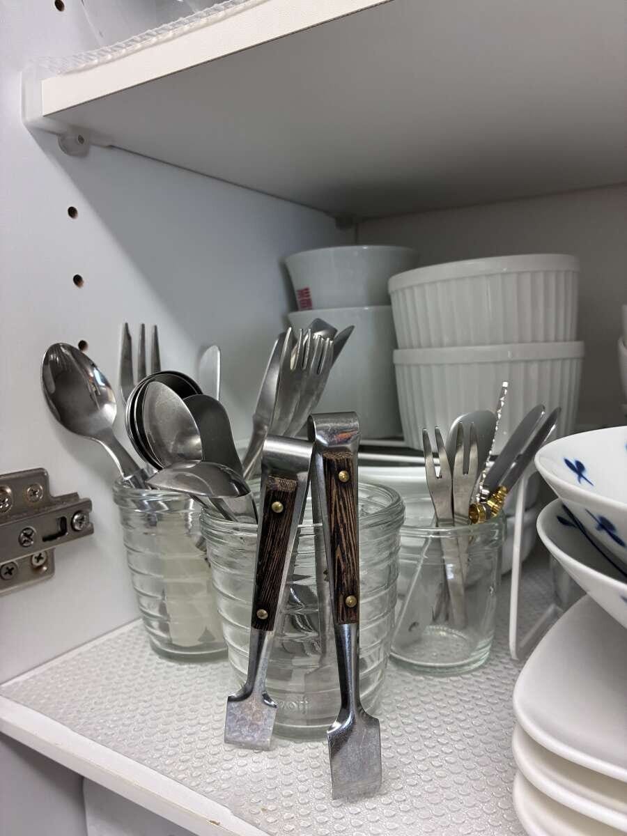 食器棚でガラスカップにカトラリーが複数収納されている