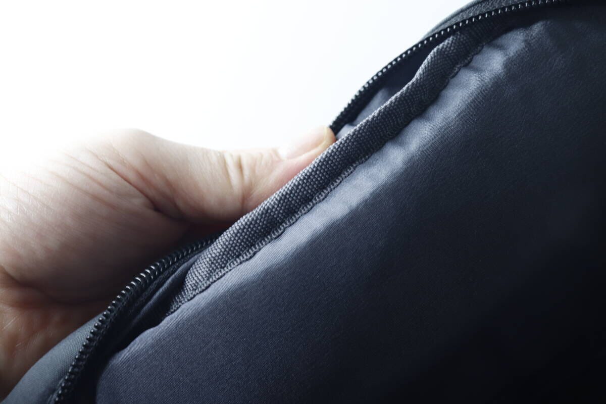 指でバッグの生地を挟んで厚みとクッション性を確認している様子