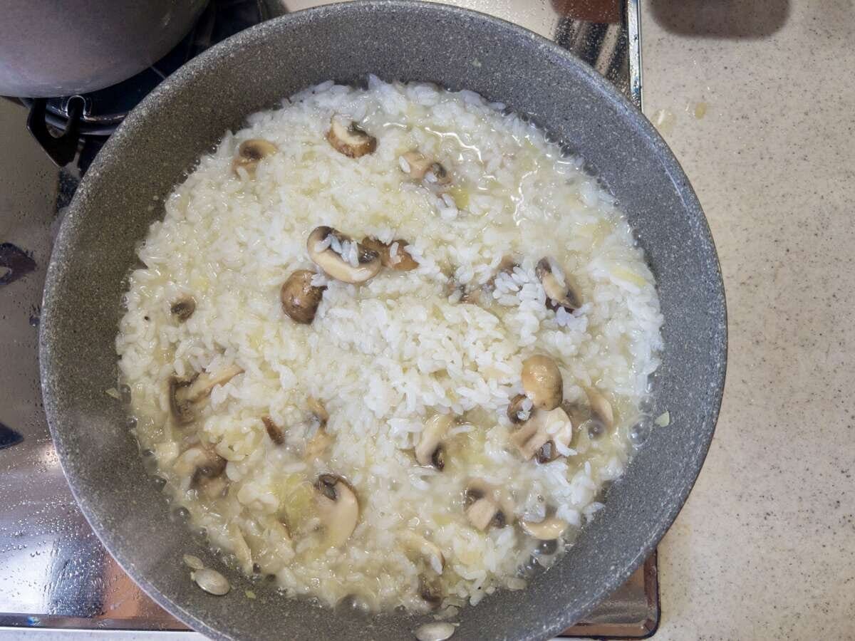 グリーンピースの茹で汁を加えてごはんを煮込んでいる様子