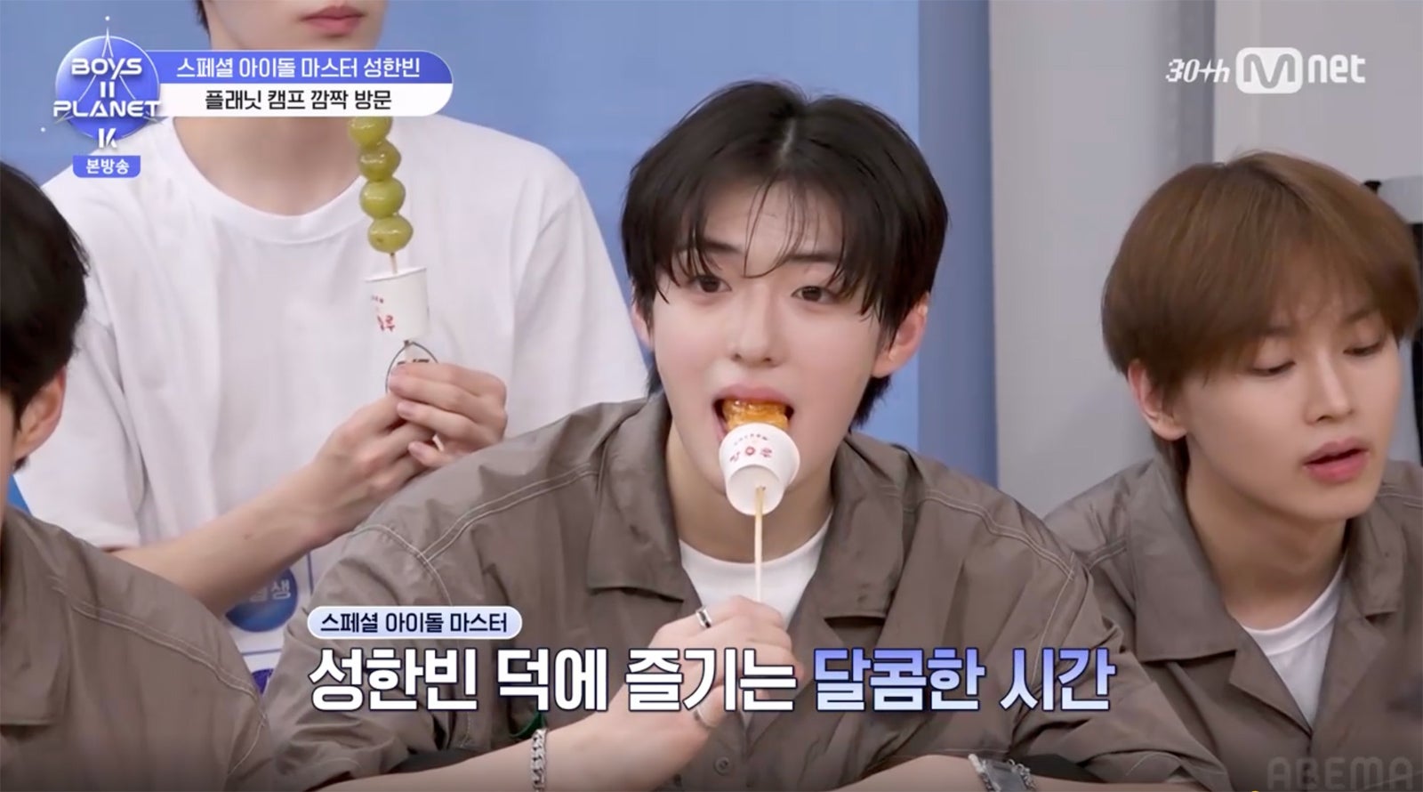 ソン・ハンビンが持ってきたタンフルを頬張る練習生（C）CJ ENM. All Rights Reserved.