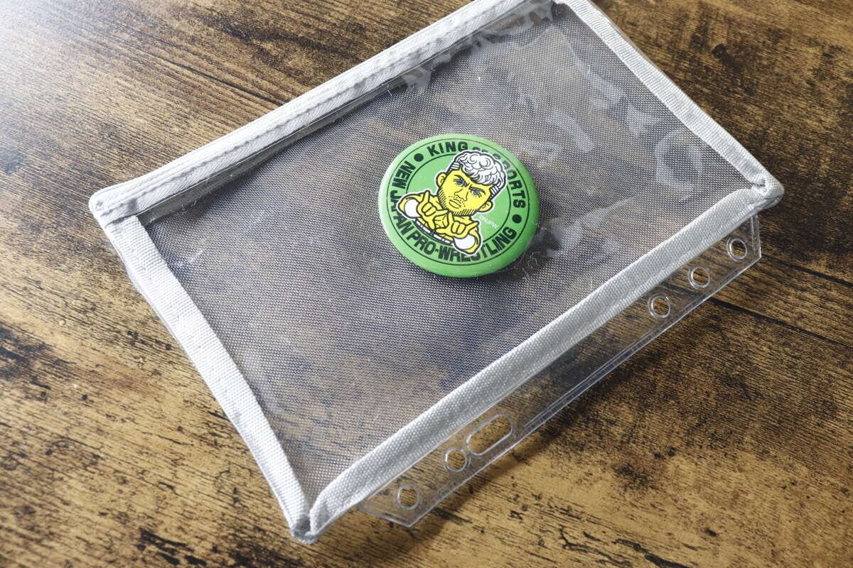 メッシュポーチリフィルの中に緑色の缶バッジが一つ入っている様子
