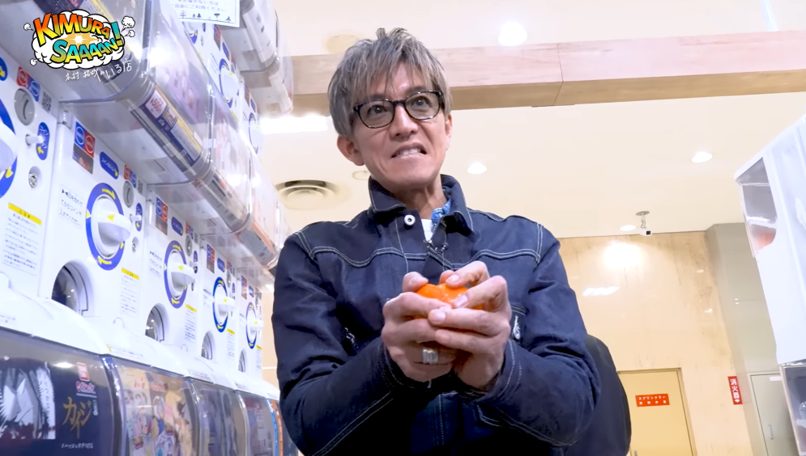 ガチャガチャを回すだけで絵になる。木村拓哉が初挑戦で見せたスターの顔