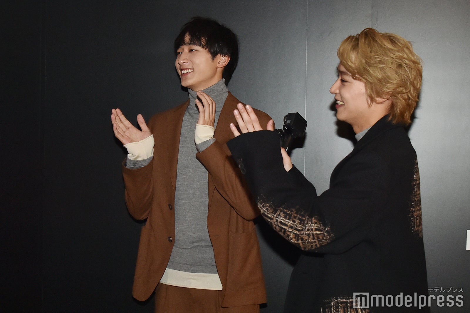 写真展で流れる「ハンサムライブ」の映像を見ながら振り付けを思い出す小関裕太、 松岡広大（C）モデルプレス