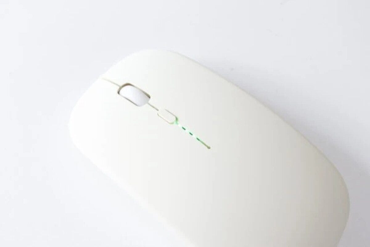 白い無線マウスの全体像。電池残量を示すライトが見える