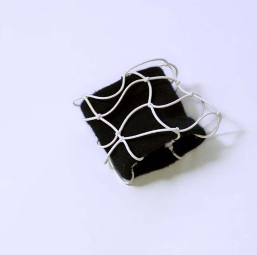 リストバンドも糸が絡まったように結んで…