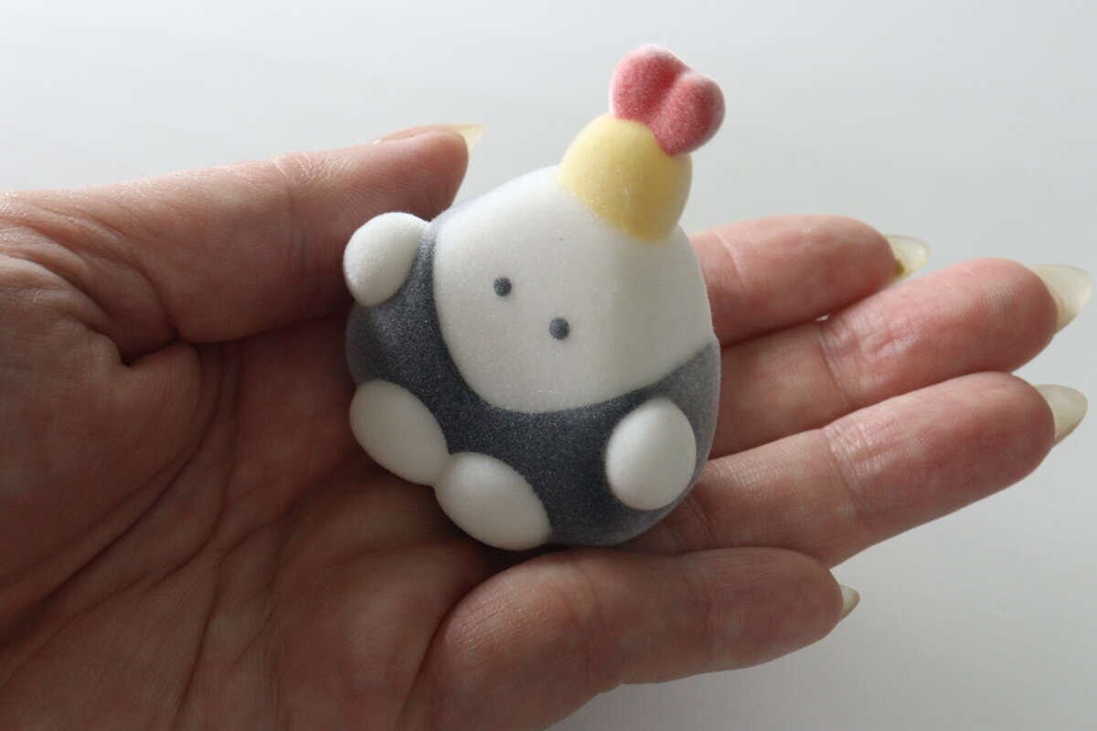 女性の手のひらに乗ったフロッキー加工の求心フレンズ「天むす」フィギュア