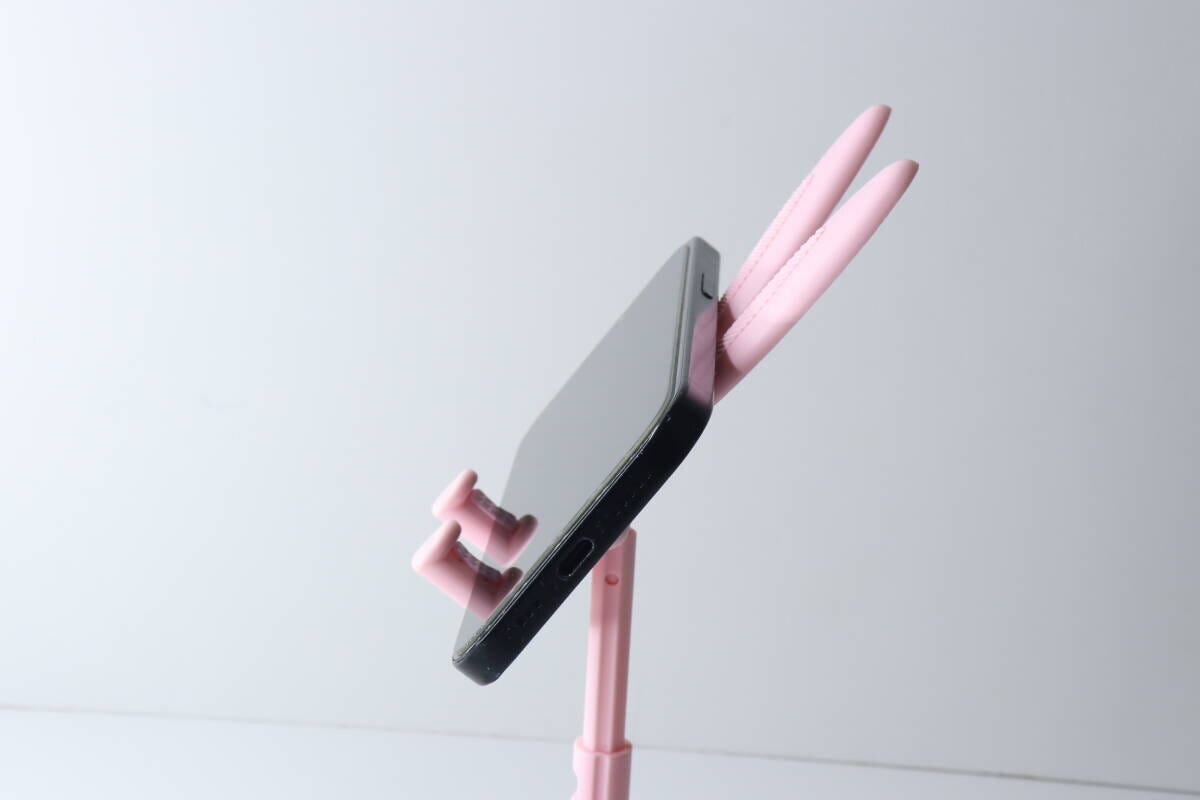 完成したピンク色のウサギ型スマホスタンドにスマホを横置きしている側面 完成したピンク色のウサギ型スマホスタンドにスマホを横置きしている側面