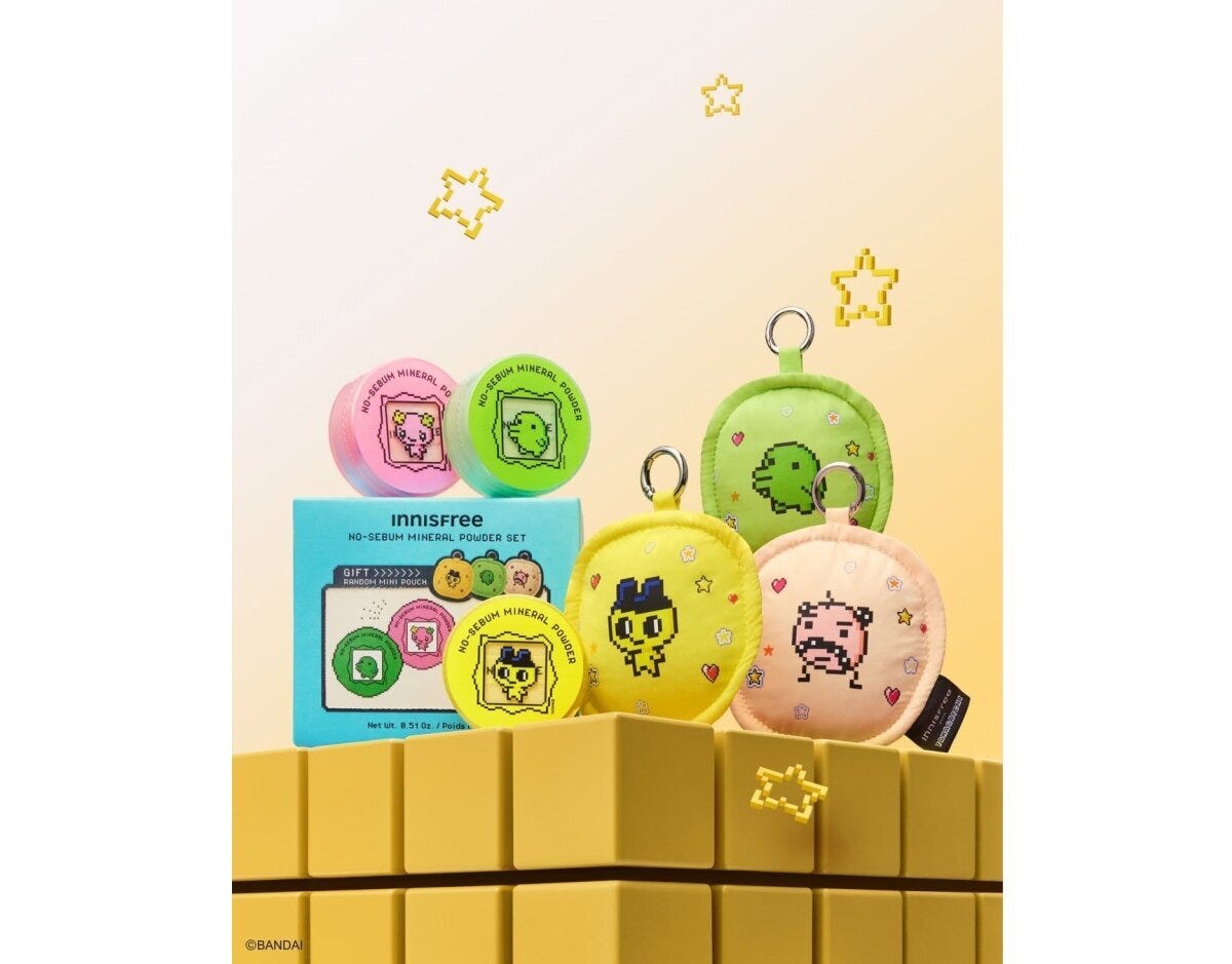 黄色いブロックの上にたまごっちデザインパウダーとキャラミニポーチ3種が並ぶ