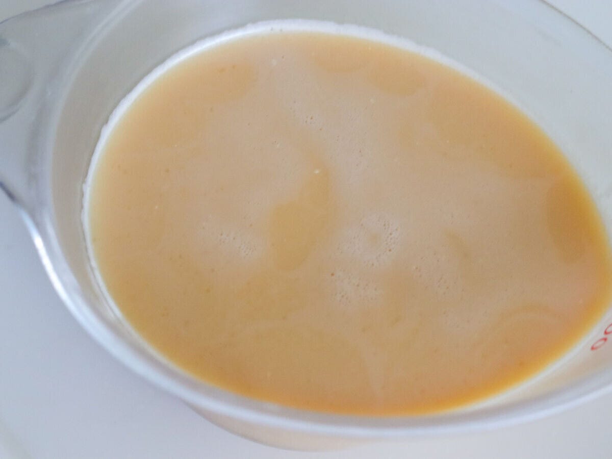 ザルで漉したなめらかなプリン液が入ったガラスボウルの俯瞰写真