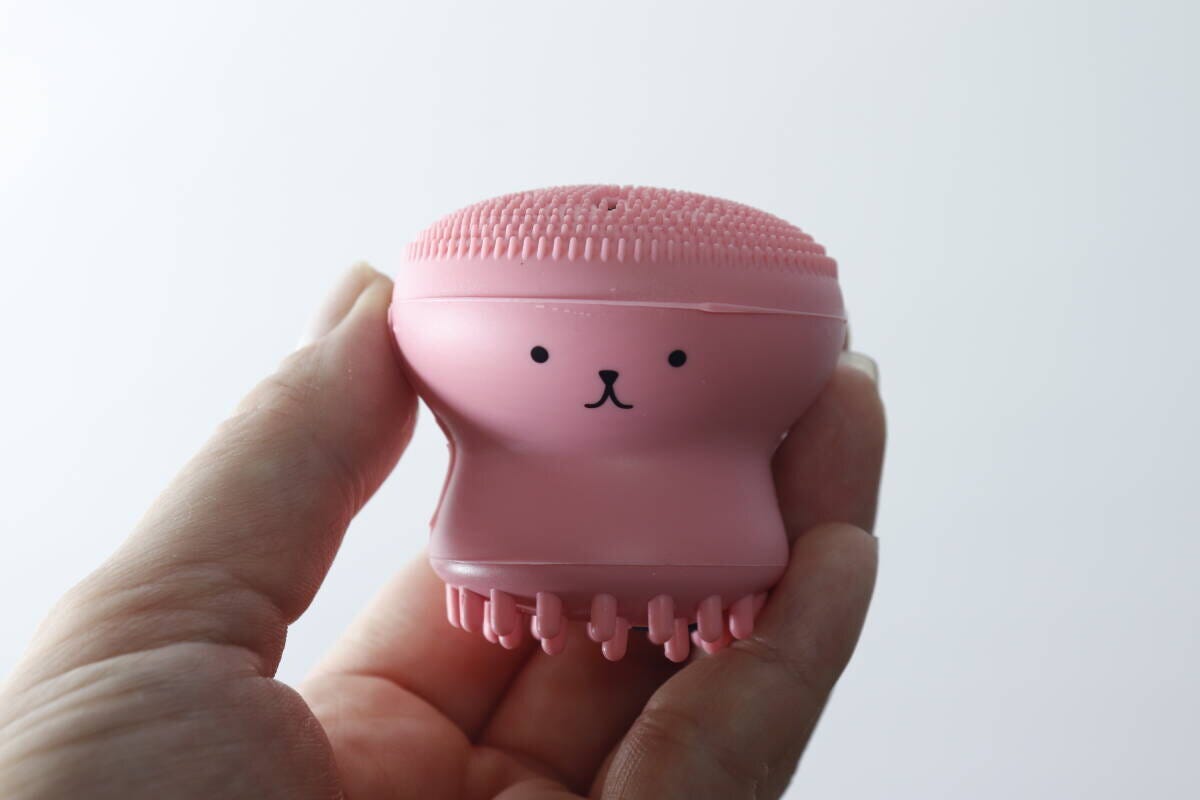 女性の手に持たれたピンク色の洗顔ブラシ。うさぎの顔が描かれている 女性の手に持たれたピンク色の洗顔ブラシ。うさぎの顔が描かれている