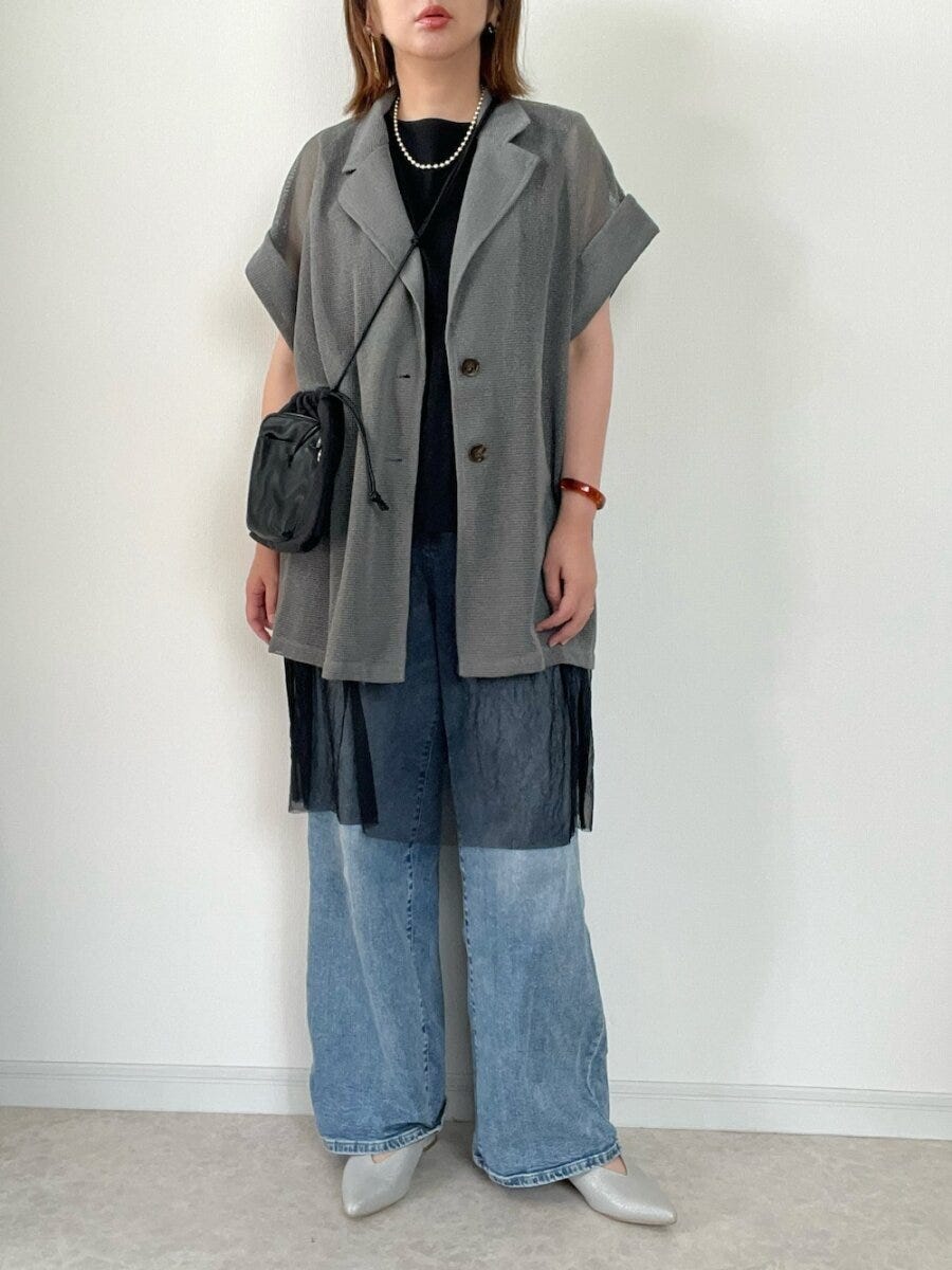 グレーのシアー半袖ジャケットとワイドデニムを着用した女性の全身 グレーのシアー半袖ジャケットとワイドデニムを着用した女性の全身