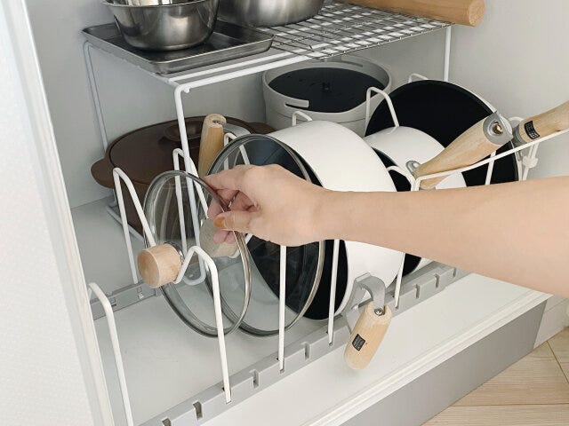 お鍋やフライパンは立てて収納　お鍋の蓋に手を掛ける
