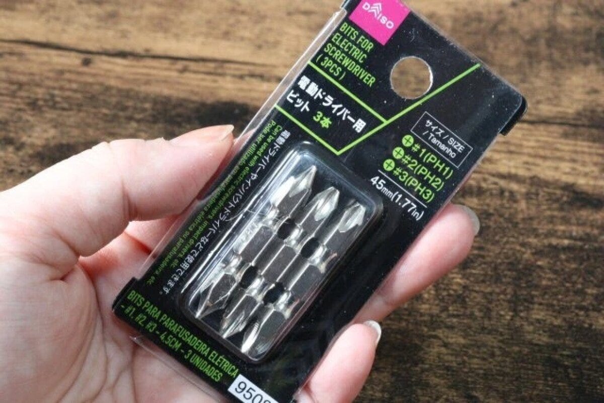 女性の手が電動ドライバー用ビットのパッケージを持つ
