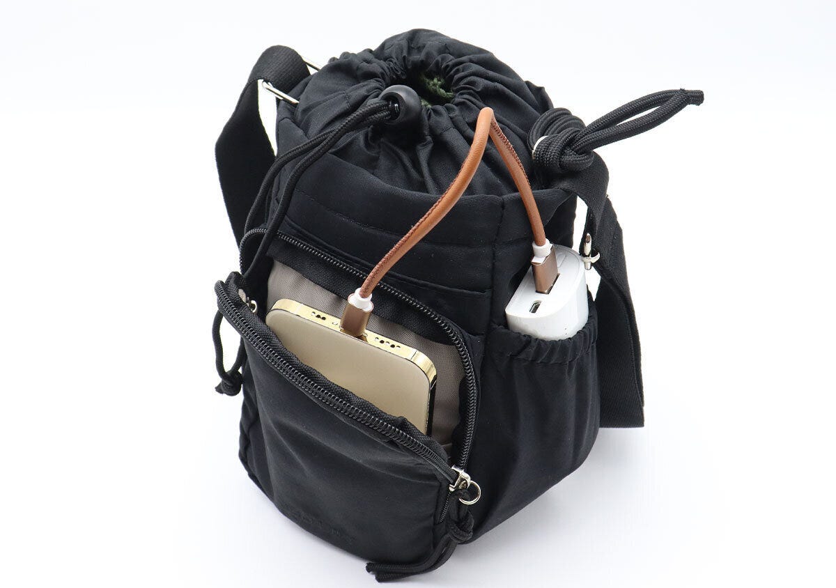 フロントポケットにスマホ、脇ポケットにモバイルバッテリーを入れて充電している様子