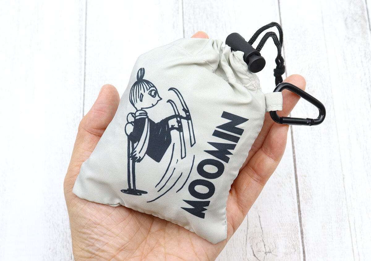 手のひらに、リトルミイのイラストと「MOOMIN」の文字が入った、小さく収納されたエコバッグが乗せられている。