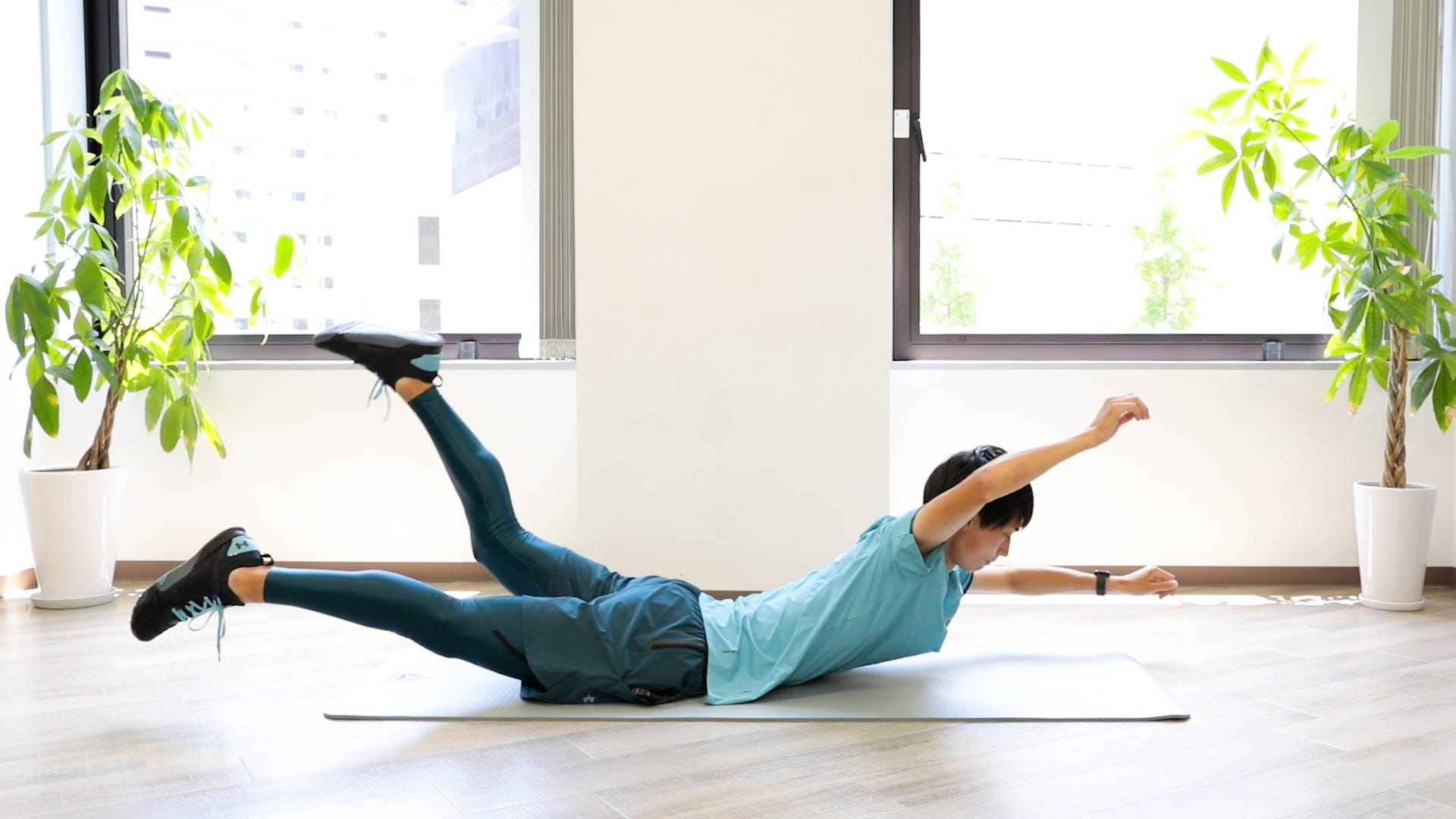 背筋を伸ばした状態で、右腕と左足を上げている図