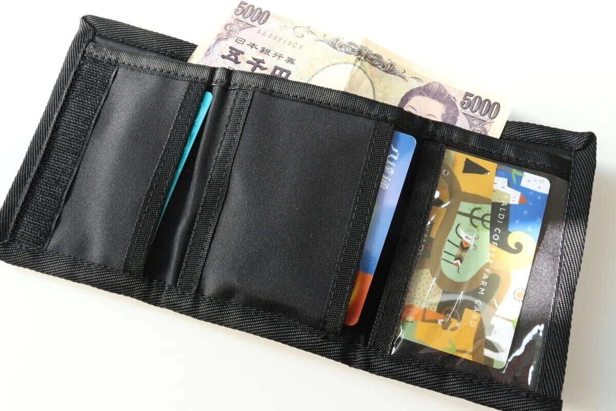 黒い紐付きキッズ三つ折りウォレットを開き、お札とカードが収納されている 黒い紐付きキッズ三つ折りウォレットを開き、お札とカードが収納されている