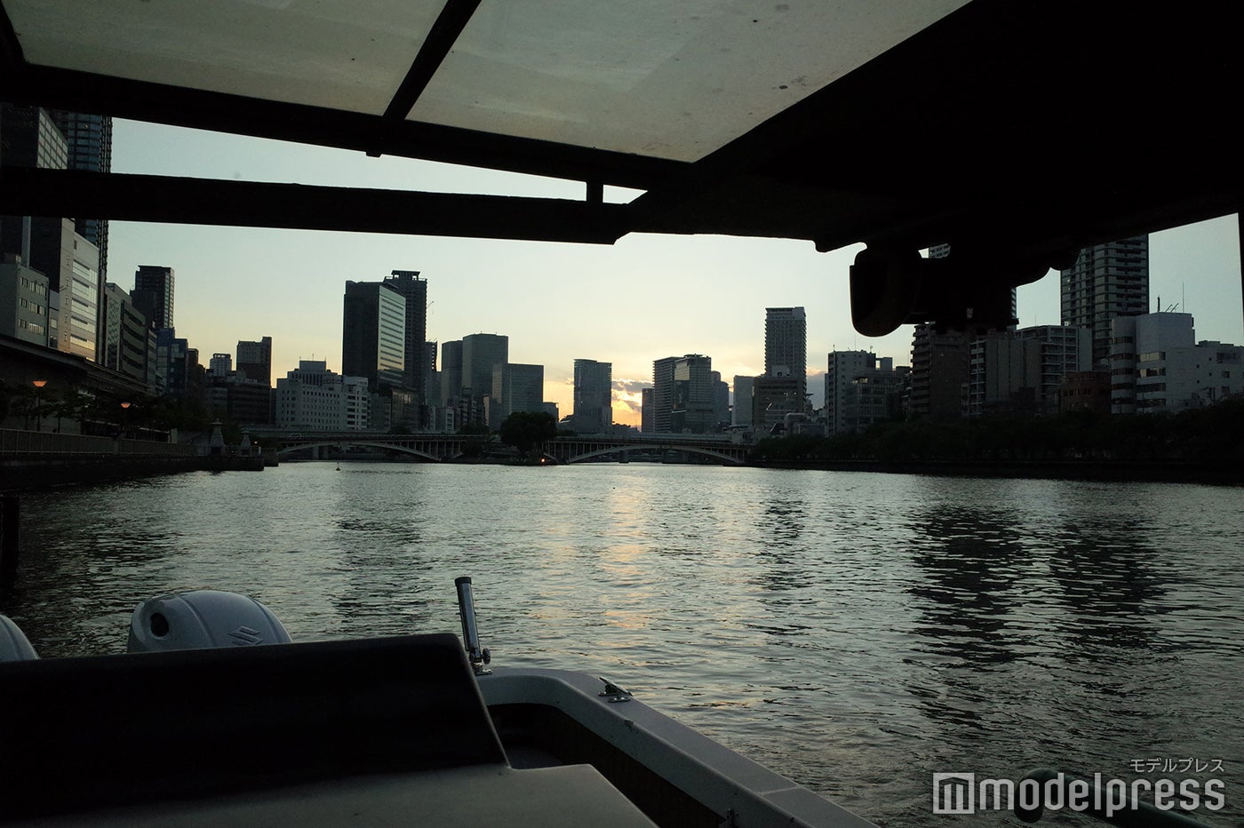 大阪の淀川の奥、夕日を背負うフォーシーズンズホテル大阪（写真中央）（C）モデルプレス