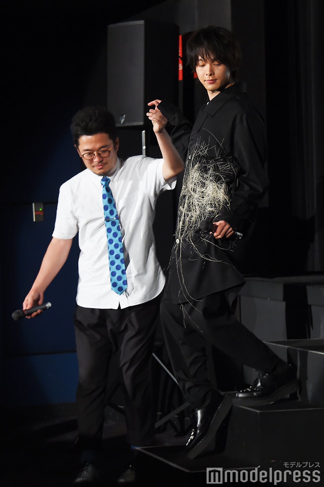 中野量太監督（左）にエスコートされ服の裾を掴みながら女優気分で降壇する中村倫也（右）／（C）モデルプレス