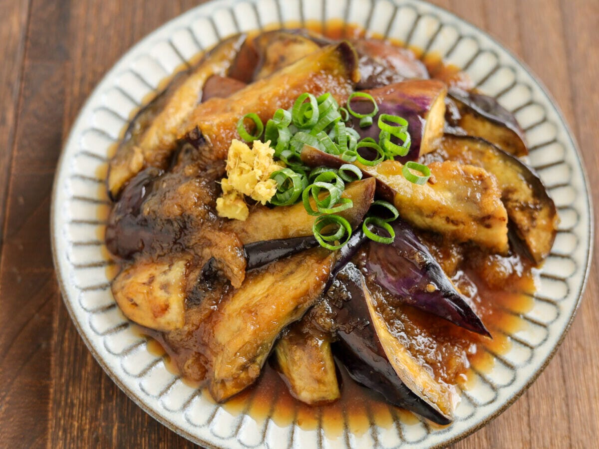 白い皿に盛り付けられたなすのみぞれ煮。青ねぎとしょうがが添えられている
