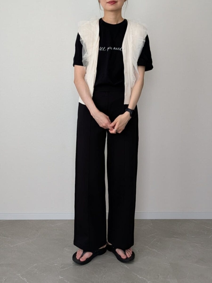 黒Tシャツと黒ストレートパンツに白チュールカーディガンを羽織った女性 黒Tシャツと黒ストレートパンツに白チュールカーディガンを羽織った女性