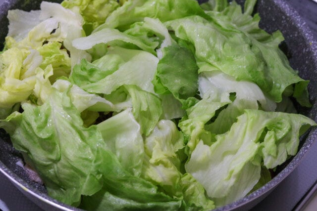 豚肉の上にレタスをのせ、塩をふってフタをし、中火で4～5分加熱する。