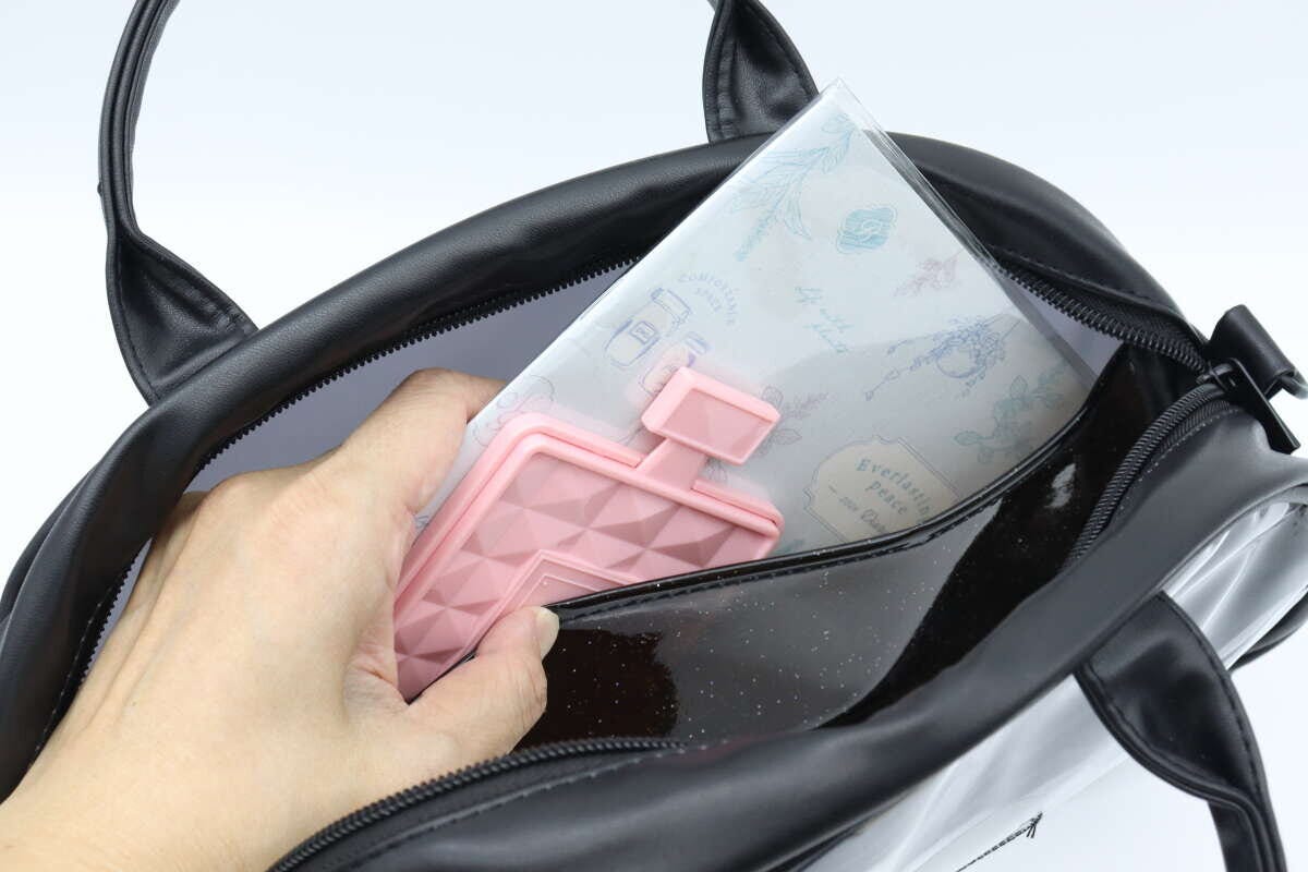 黒いクリアバッグのメイン収納部にハンディファンと手帳を入れている