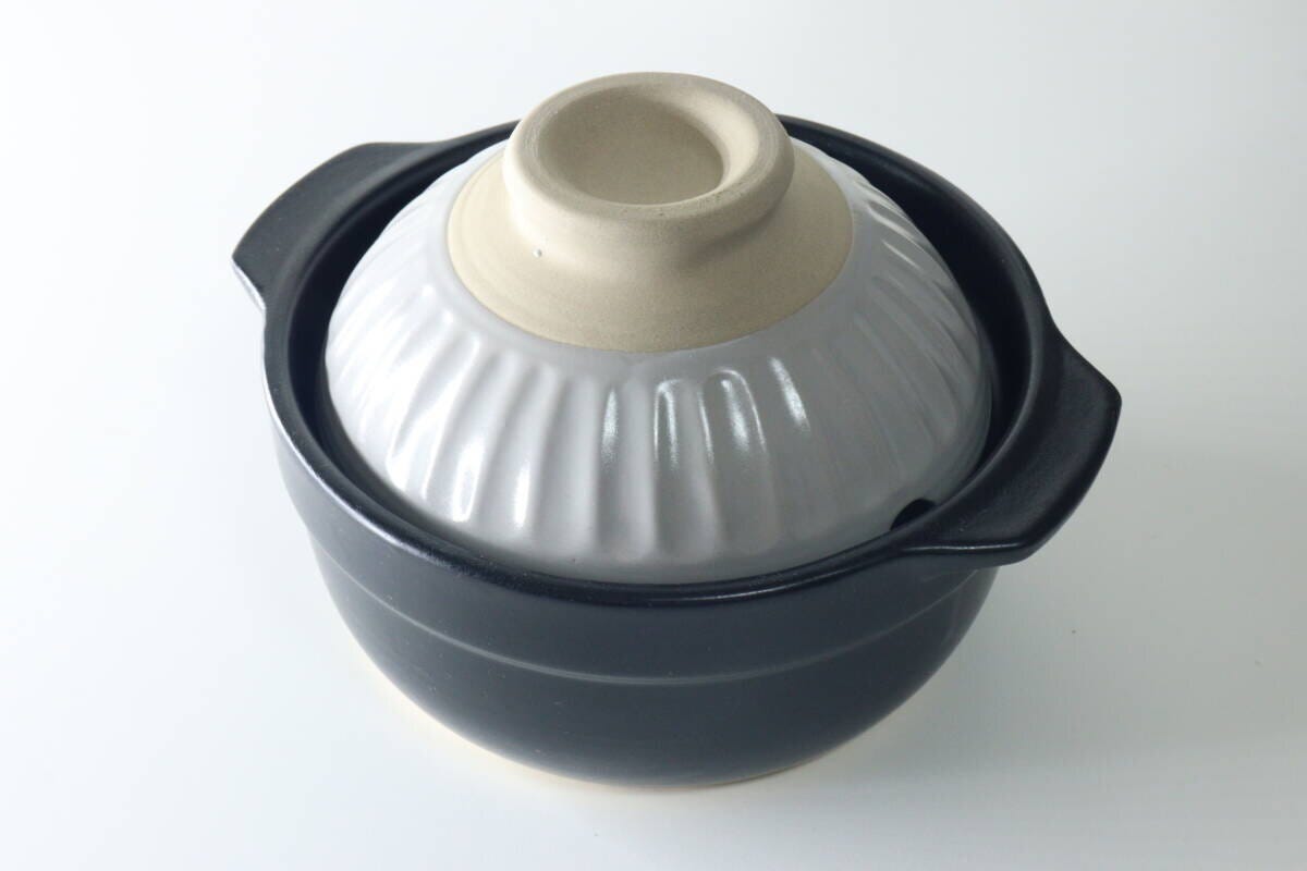 グレーの蓋が乗った黒いコンパクトな土鍋 グレーの蓋が乗った黒いコンパクトな土鍋