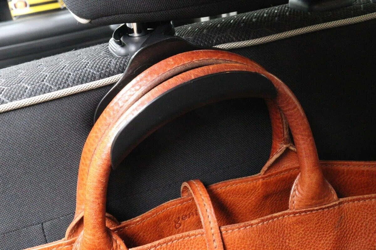 車のヘッドレストに掛けられたバッグフックに茶色いバッグが吊るされている 車のヘッドレストに掛けられたバッグフックに茶色いバッグが吊るされている