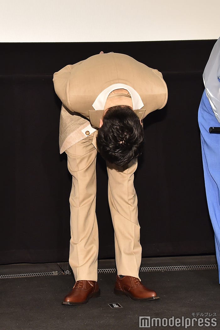 バミリに頭が届きそうなくらいまで深くお辞儀をする田中圭(C)モデルプレス