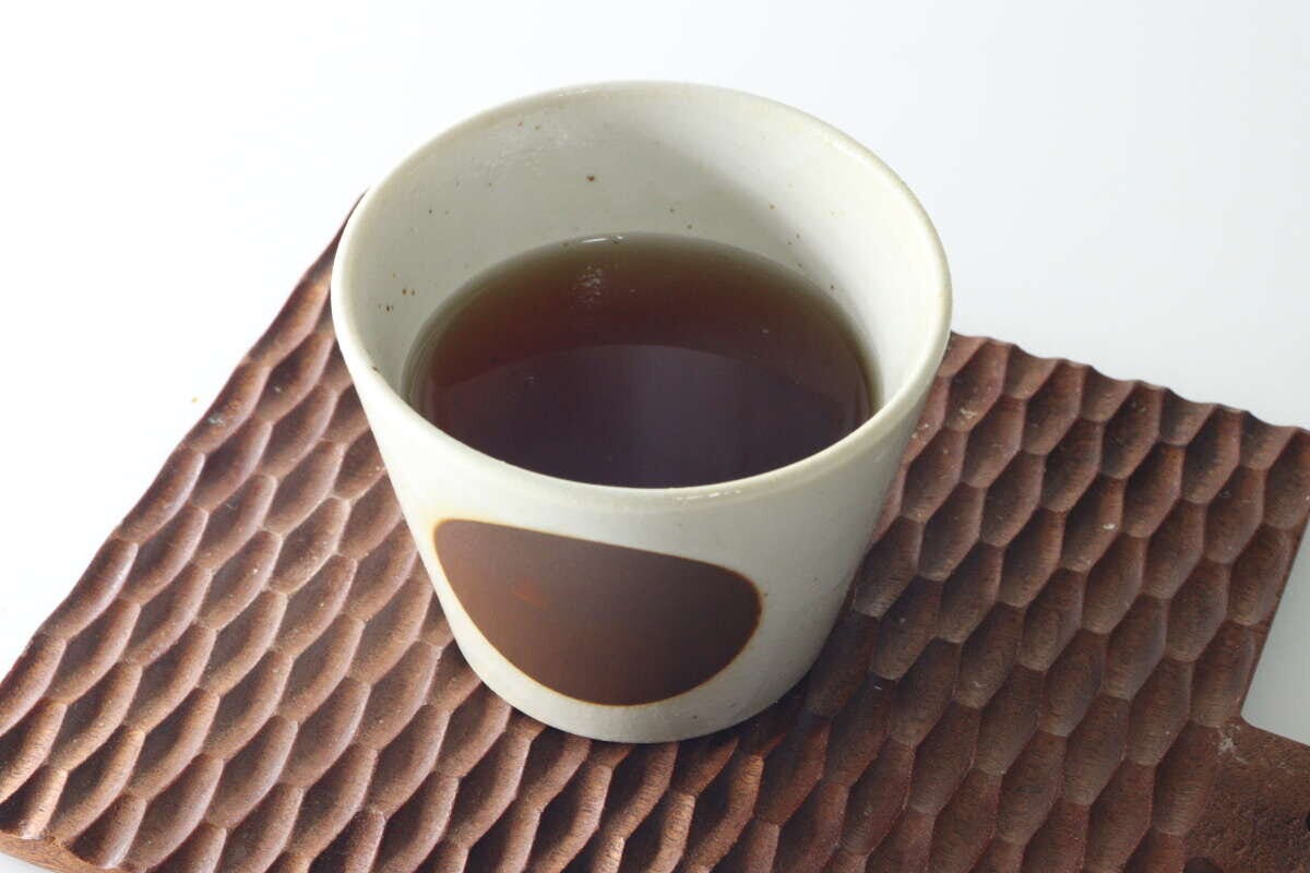 湯呑み茶碗に淹れたてのやきいも茶が注がれている俯瞰写真 湯呑み茶碗に淹れたてのやきいも茶が注がれている俯瞰写真
