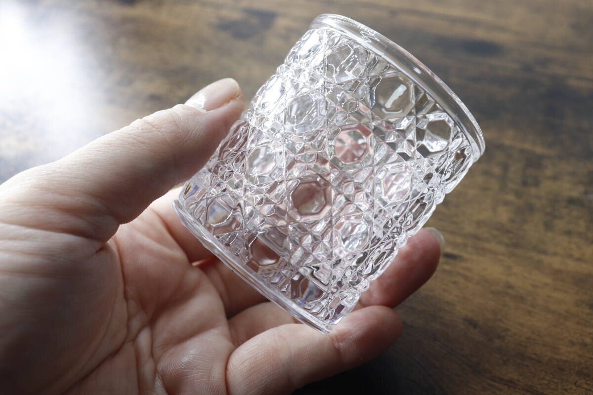 凹凸模様が特徴のミニグラスを片手で持っている様子