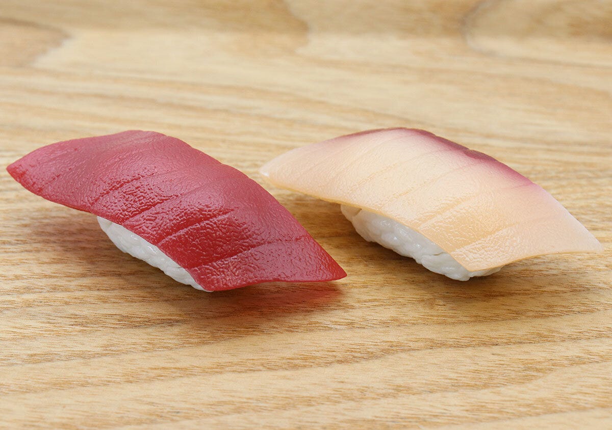 木目のテーブルに置かれた、リアルなまぐろとはまちの寿司パズルを斜めからアップで撮影