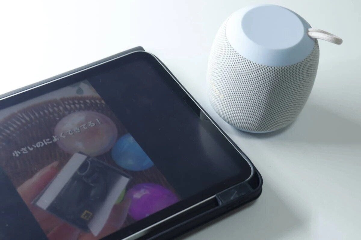 丸いスピーカーとタブレット端末が並んで置かれている 丸いスピーカーとタブレット端末が並んで置かれている