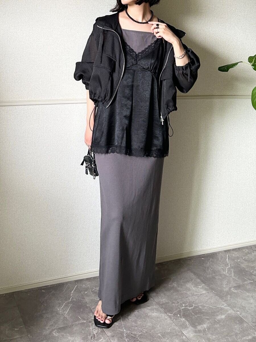 グレーのIラインワンピースに黒いサテンキャミソールと黒いブルゾンを重ね着した女性の全身
