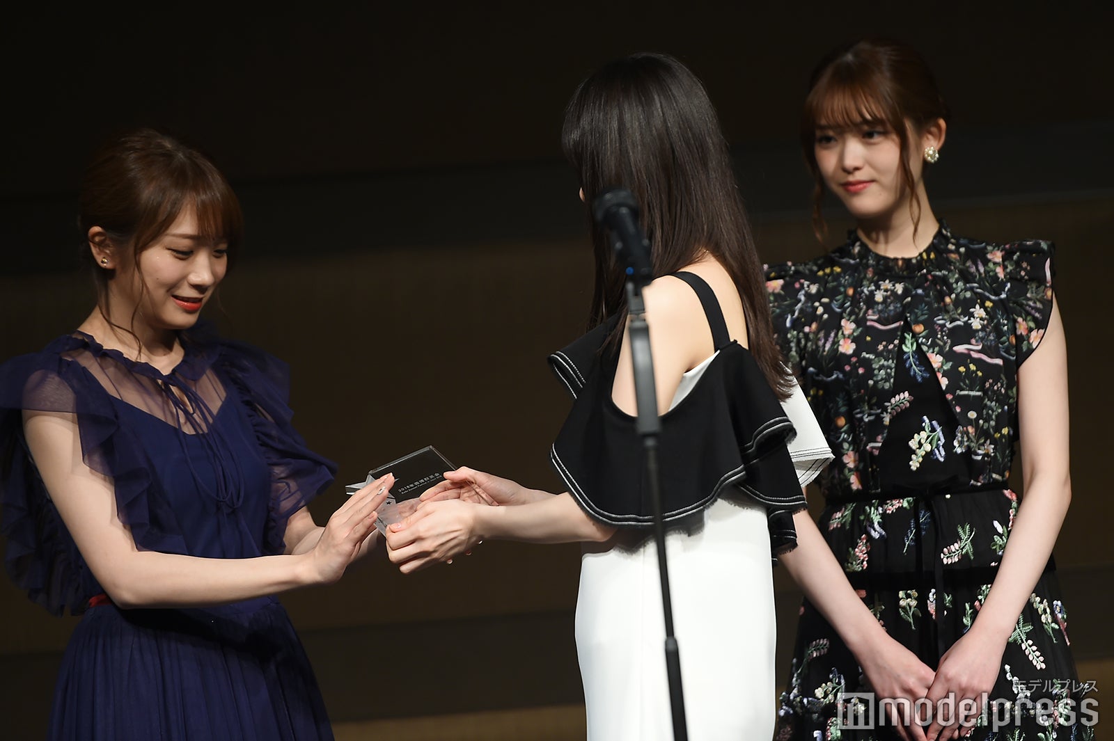 スピーチ直前、トロフィーを秋元真夏（左）に預ける齋藤飛鳥（中央）（C）モデルプレス