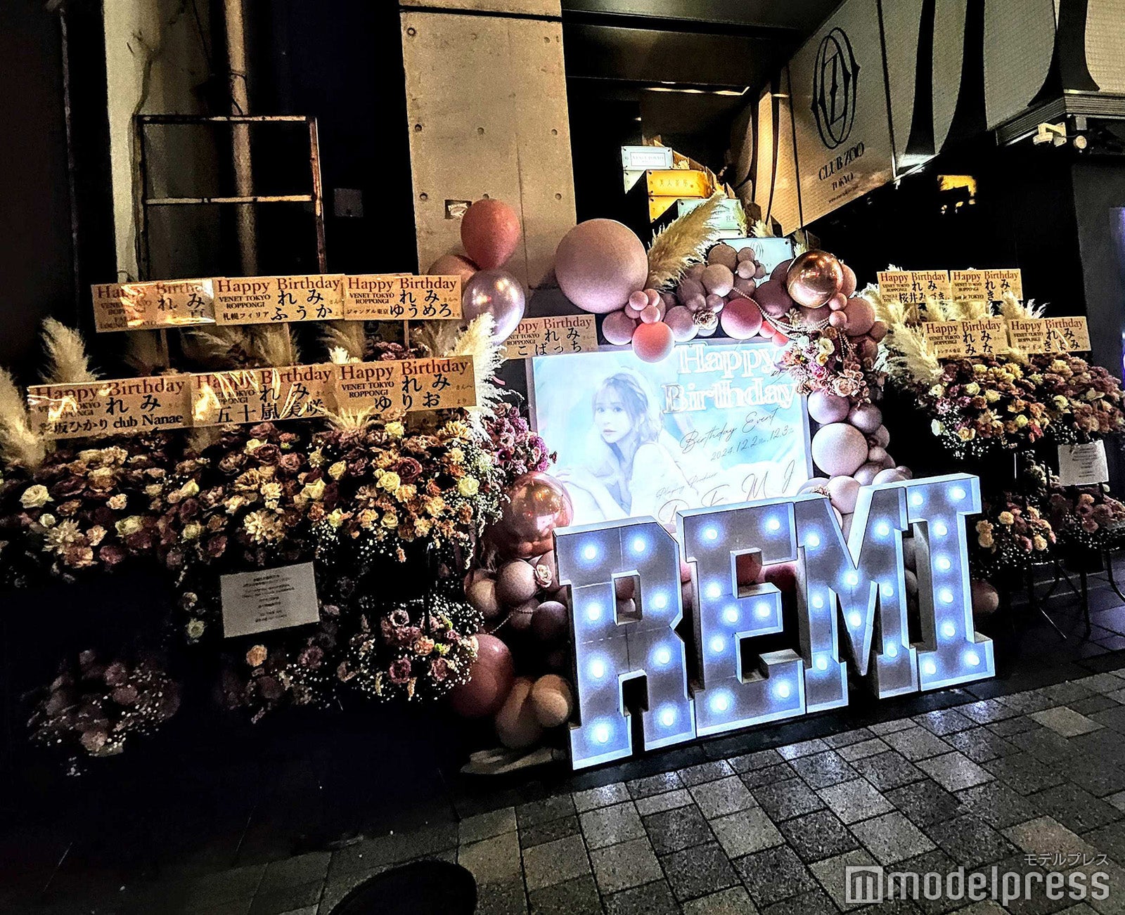 ビル入口。祝花も豪華な顔ぶれがずらり（C）モデルプレス