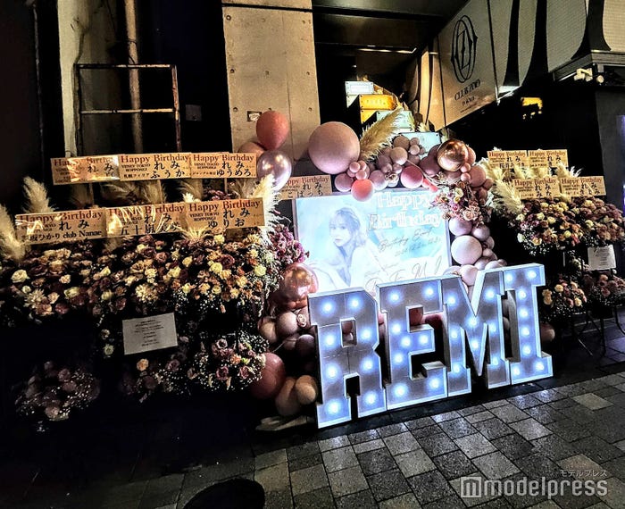 ビル入口。祝花も豪華な顔ぶれがずらり(C)モデルプレス