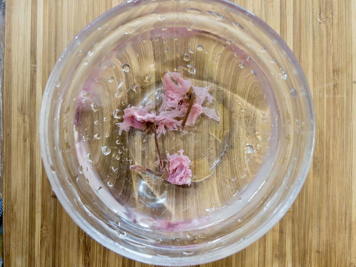 桜の塩漬けを小さめのボウルに入れ、水を注いで塩抜きをします 桜の塩漬けを小さめのボウルに入れ、水を注いで塩抜きをします
