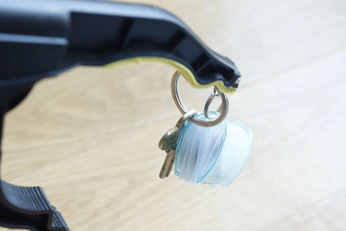 マジックハンドの先端で鍵とキーホルダーをしっかりと掴んでいる マジックハンドの先端で鍵とキーホルダーをしっかりと掴んでいる