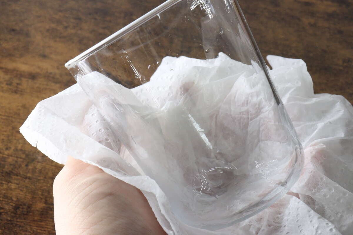 キッチンペーパーでグラスに残った水滴を拭き取っている手元 キッチンペーパーでグラスに残った水滴を拭き取っている手元