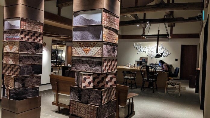 寄木と白黒写真のアートワーク越しに、レセプションを望む（ホテルインディゴ箱根強羅） 