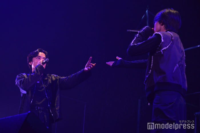 見つめ合い手を差し伸べるKANONとRUI(C)モデルプレス