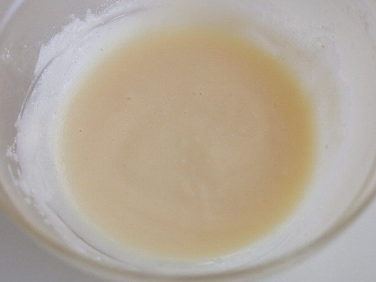 透明なボウルに入った乳白色の液体(ヨーグルト、米油、砂糖、レモン汁)の俯瞰 透明なボウルに入った乳白色の液体(ヨーグルト、米油、砂糖、レモン汁)の俯瞰