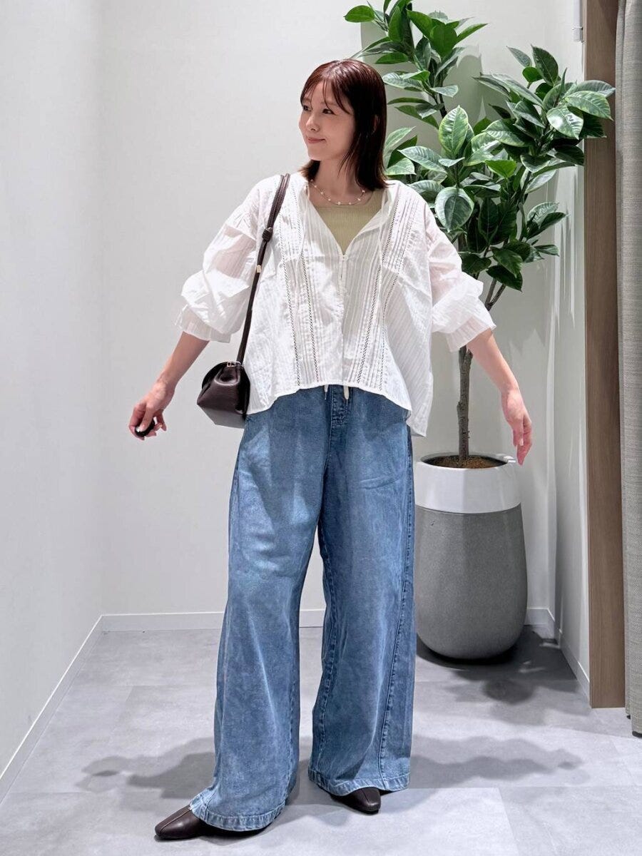 白いレースブラウスとデニムワイドパンツの女性 白いレースブラウスとデニムワイドパンツの女性