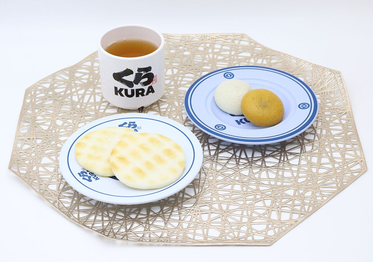 くら寿司の食器に和菓子が盛り付けられ、湯呑みにお茶が注がれている くら寿司の食器に和菓子が盛り付けられ、湯呑みにお茶が注がれている