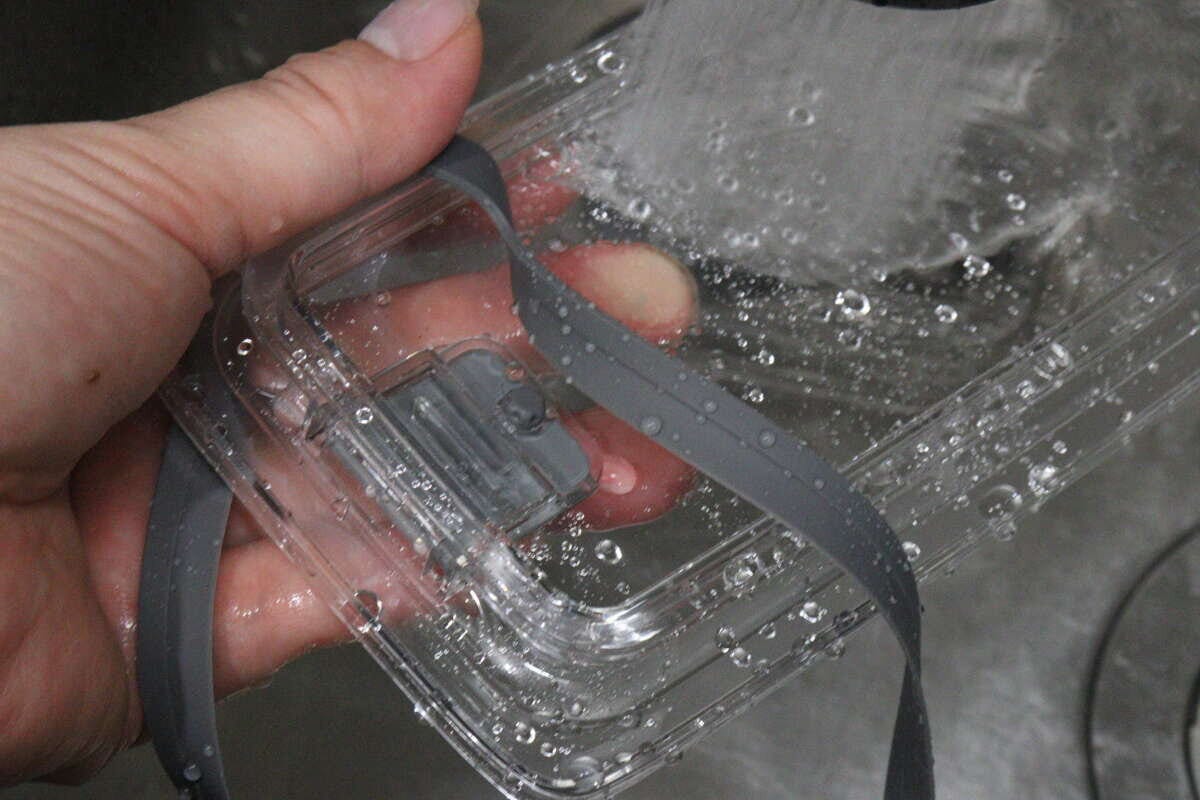 密閉容器のフタとパッキンを流水で洗っている手元 密閉容器のフタとパッキンを流水で洗っている手元